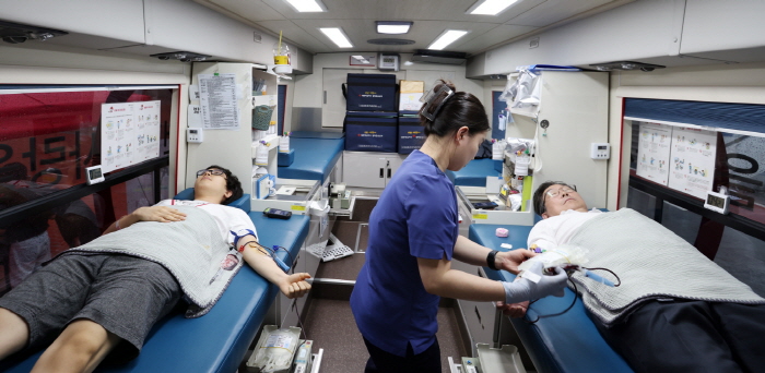 김동원 고려대 총장(오른쪽)이 학생들과 함께 헌혈버스에서 헌혈하고 있다.